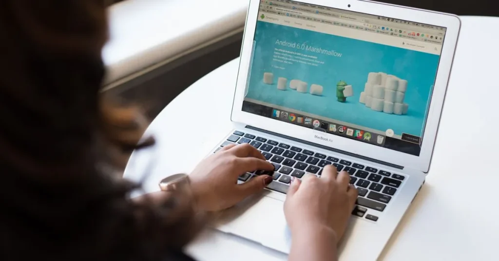 Businesswoman working on laptop with Android 6.0 Marshmallow webpage open.