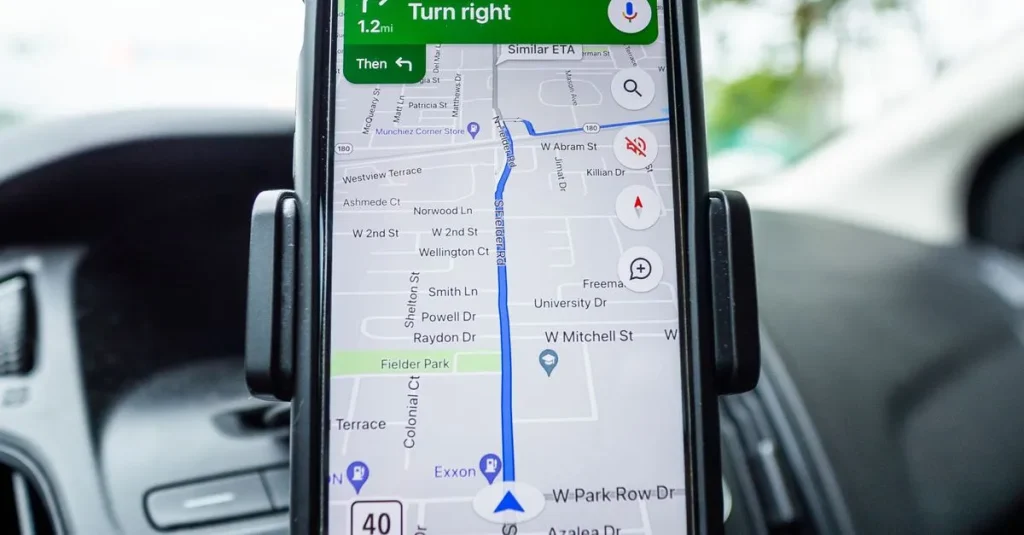 Close-up of a smartphone with GPS navigation app mounted on car dashboard.