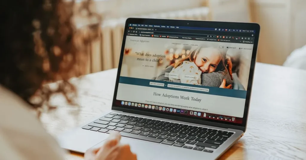 A woman researching adoption information on a laptop indoors.